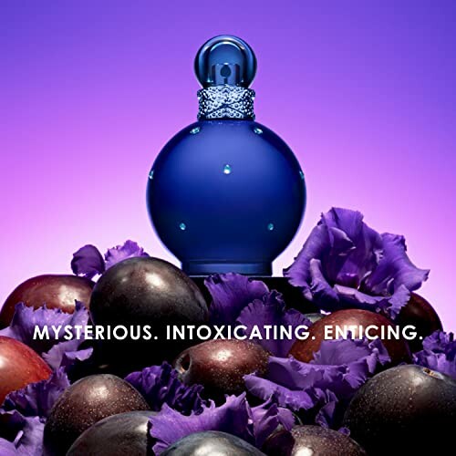 Blue perfume bottle with purple flowers and plums on a vibrant background.