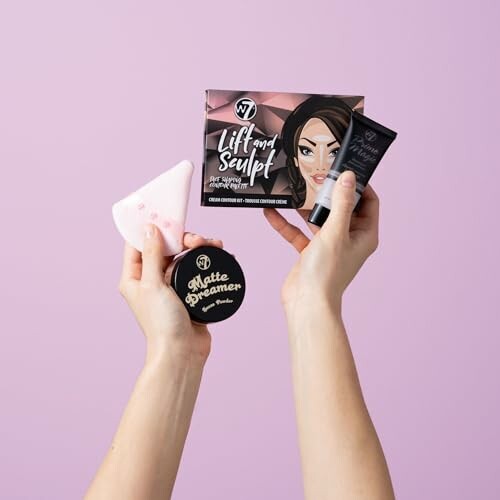 Hands holding makeup products against a pink background